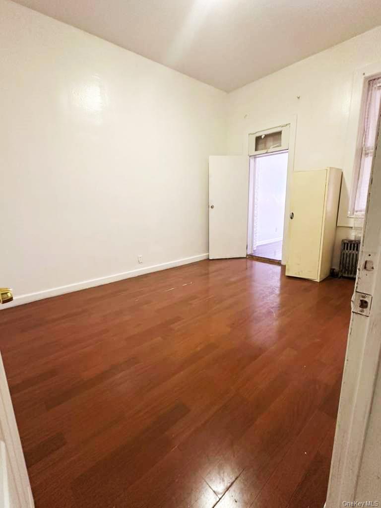 88-22 85th Street Queens, NY 11421 - Photo 14 of 39 an empty room with wooden floor and windows