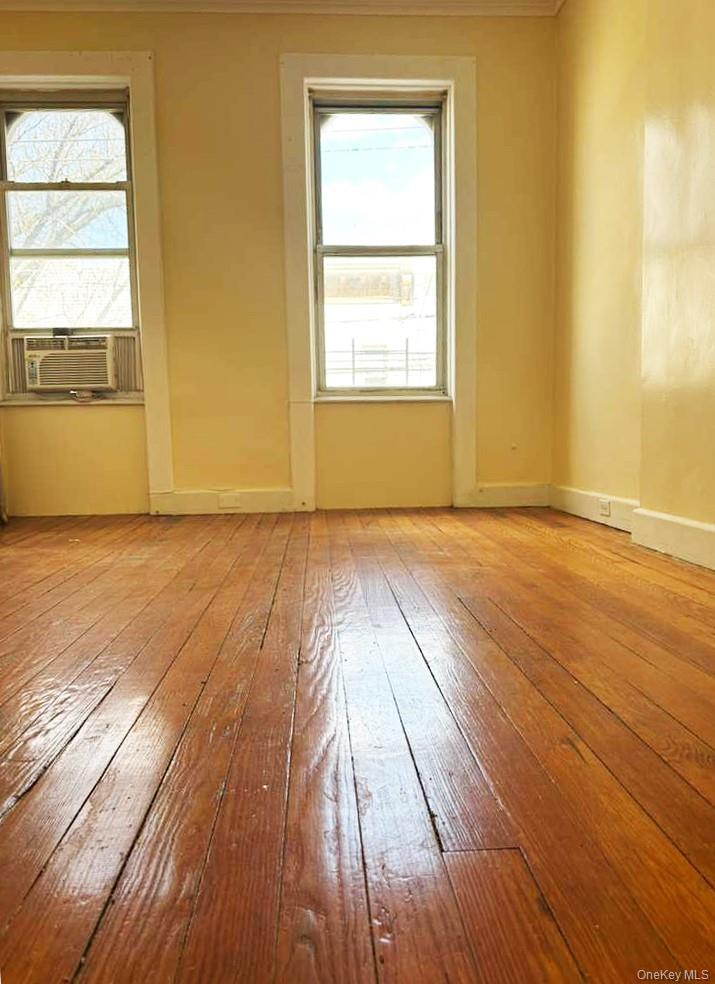 88-22 85th Street Queens, NY 11421 - Photo 2 of 39 an empty room with wooden floor and windows