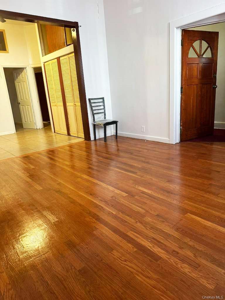 88-22 85th Street Queens, NY 11421 - Photo 24 of 39 a view of an empty room with wooden floor and a window
