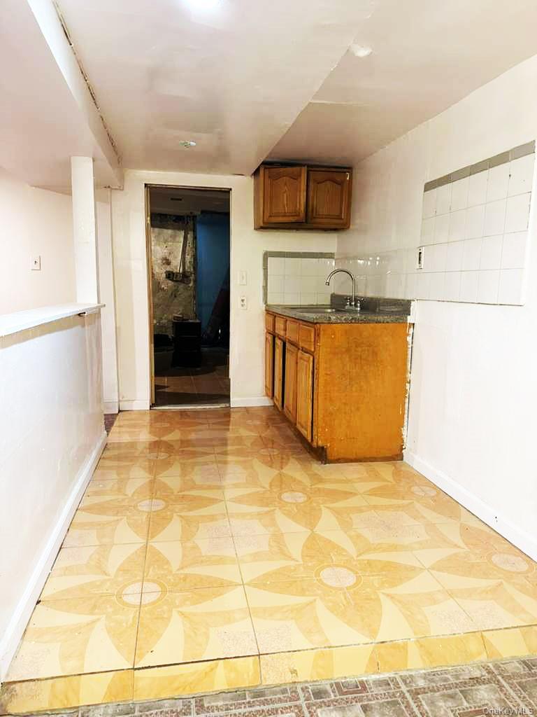 88-22 85th Street Queens, NY 11421 - Photo 28 of 39 a view of a kitchen with kitchen island granite countertop refrigerator and stove top oven