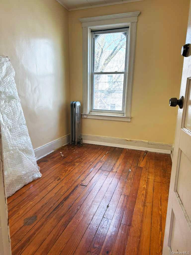 88-22 85th Street Queens, NY 11421 - Photo 3 of 39 an empty room with wooden floor and windows