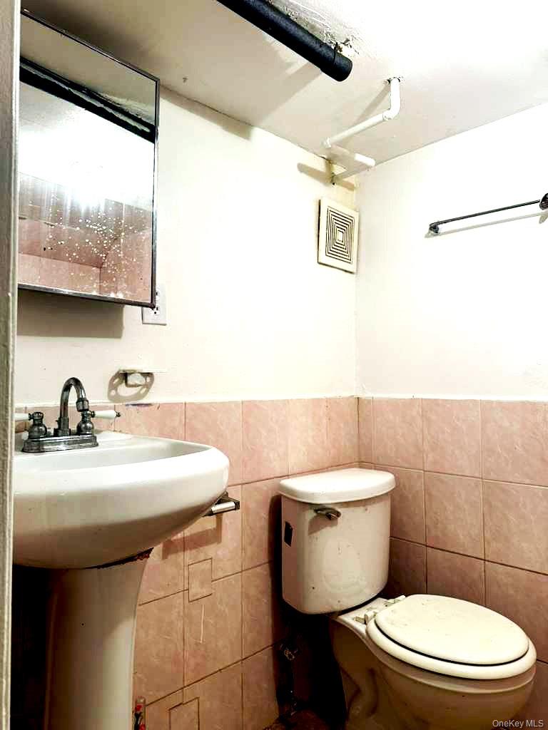88-22 85th Street Queens, NY 11421 - Photo 31 of 39 a bathroom with a sink a toilet and a mirror