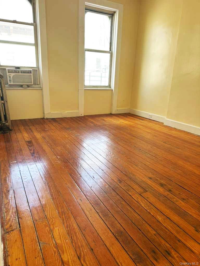 88-22 85th Street Queens, NY 11421 - Photo 7 of 39 an empty room with wooden floor and windows