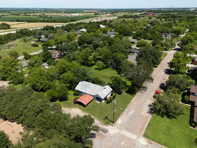 an aerial view of a house with a yard and lake view