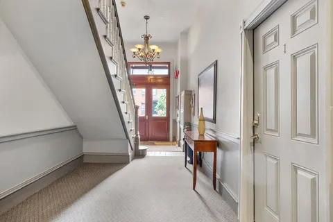 a view of an entryway with hardwood floor and livingroom