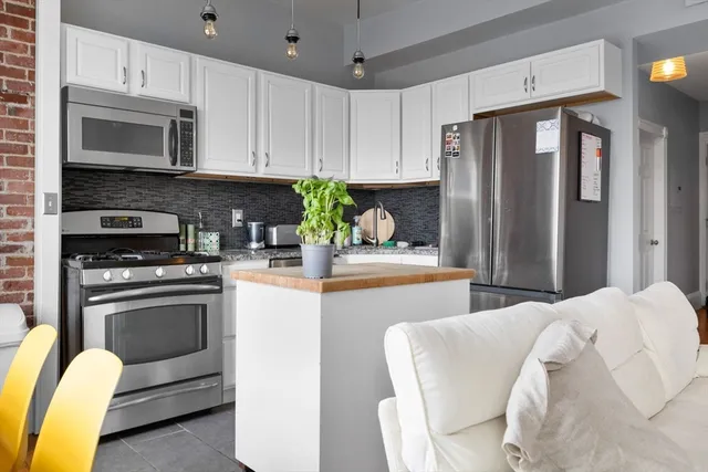 a kitchen with stainless steel appliances granite countertop a refrigerator a stove top oven a sink and dishwasher