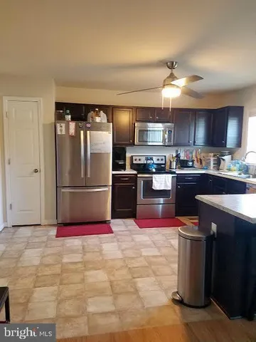 a kitchen with stainless steel appliances granite countertop a refrigerator stove top oven and sink