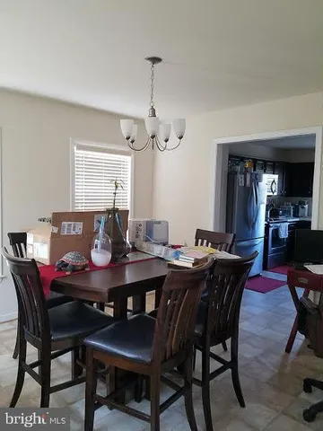 a view of a dining room and livingroom furniture wooden table a rug and a chandelier