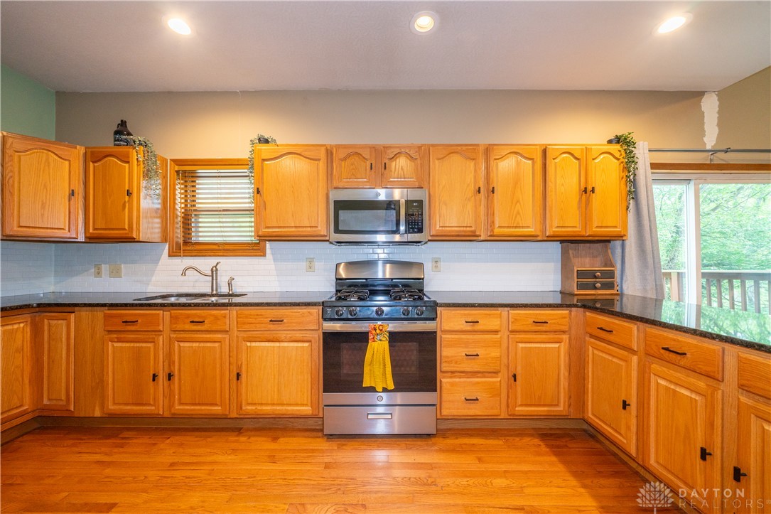 10584 New Biddinger Road Harrison, OH 45030 - Photo 5 of 61 This spacious kitchen offers ample cabinetry, modern appliances, and a beautiful wood floor.