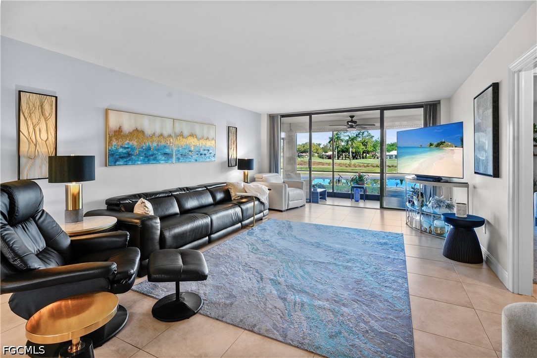 413 Augusta Boulevard, Unit 105 Naples, FL 34113 - Photo 11 of 45 a living room with furniture and a flat screen tv
