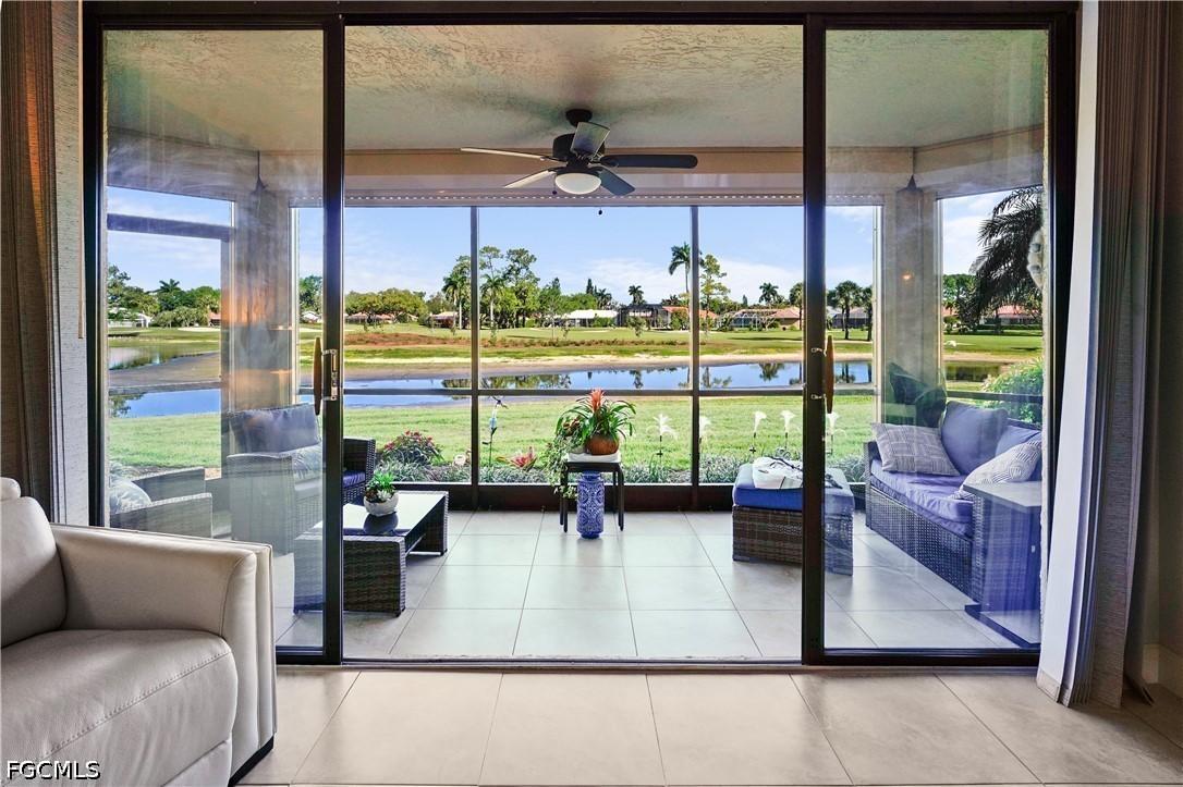 413 Augusta Boulevard, Unit 105 Naples, FL 34113 - Photo 12 of 45 a living room with couch and a floor to ceiling window with an outdoor view