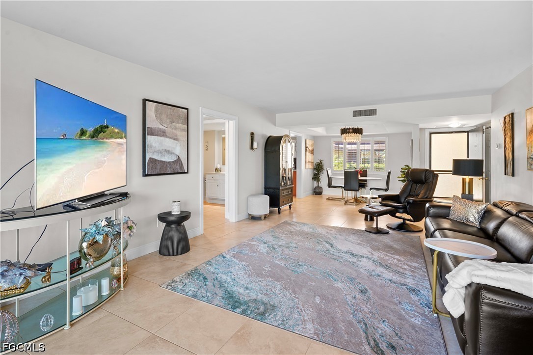 413 Augusta Boulevard, Unit 105 Naples, FL 34113 - Photo 13 of 45 a living room with furniture a flat screen tv and a window