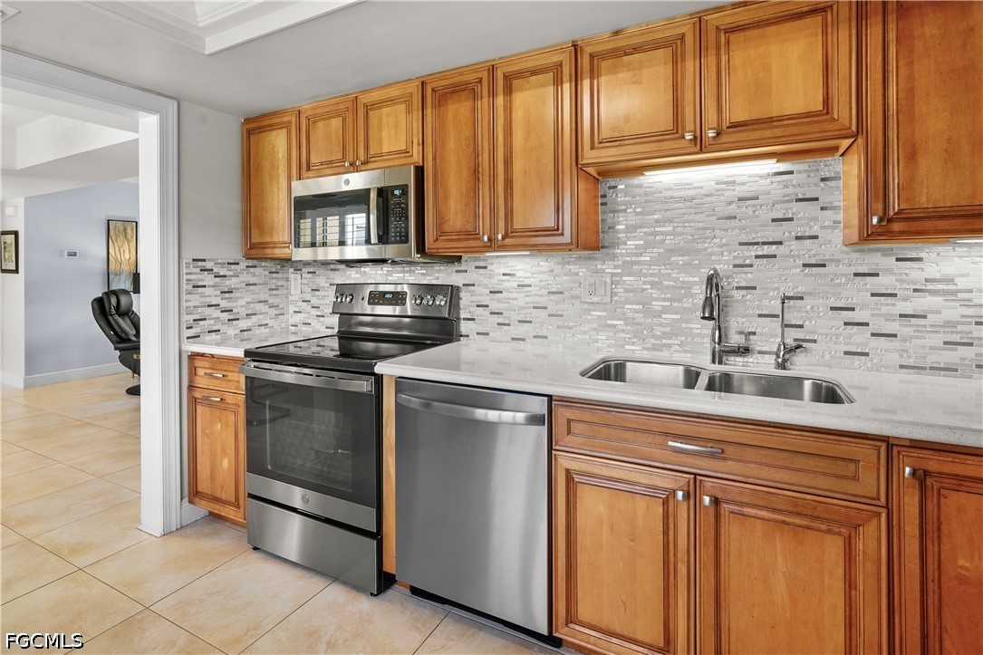 413 Augusta Boulevard, Unit 105 Naples, FL 34113 - Photo 18 of 45 a kitchen with stainless steel appliances granite countertop a sink stove and microwave