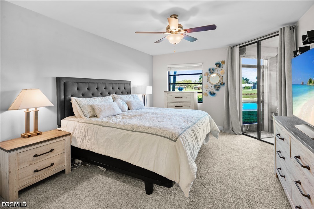 413 Augusta Boulevard, Unit 105 Naples, FL 34113 - Photo 22 of 45 a bedroom with a bed chandelier and a window