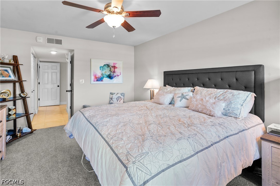 413 Augusta Boulevard, Unit 105 Naples, FL 34113 - Photo 24 of 45 a spacious bedroom with a bed and a flat screen tv