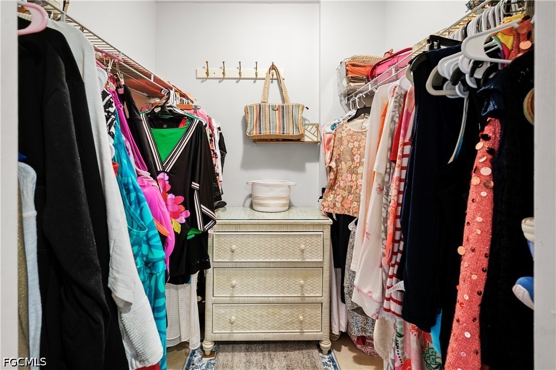 413 Augusta Boulevard, Unit 105 Naples, FL 34113 - Photo 26 of 45 a view of walk in closet with clothes and shoes