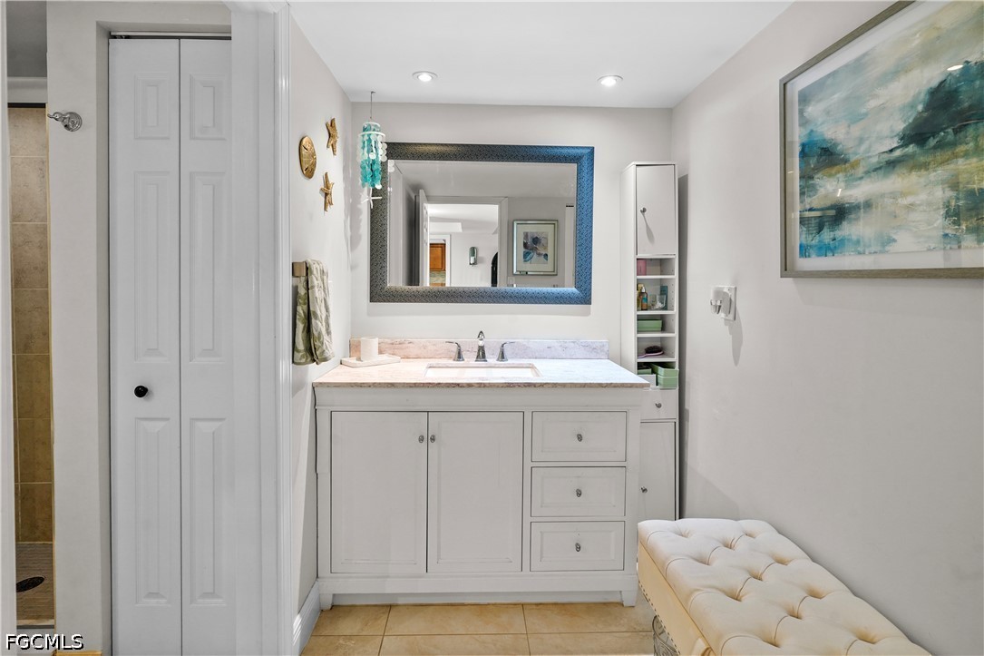413 Augusta Boulevard, Unit 105 Naples, FL 34113 - Photo 28 of 45 a bathroom with a sink a mirror and a bathtub