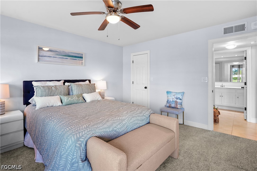 413 Augusta Boulevard, Unit 105 Naples, FL 34113 - Photo 33 of 45 a bedroom with a large bed and a chandelier