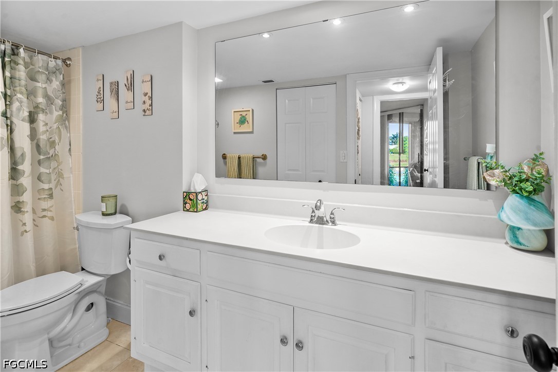 413 Augusta Boulevard, Unit 105 Naples, FL 34113 - Photo 35 of 45 a bathroom with a granite countertop sink mirror vanity and toilet