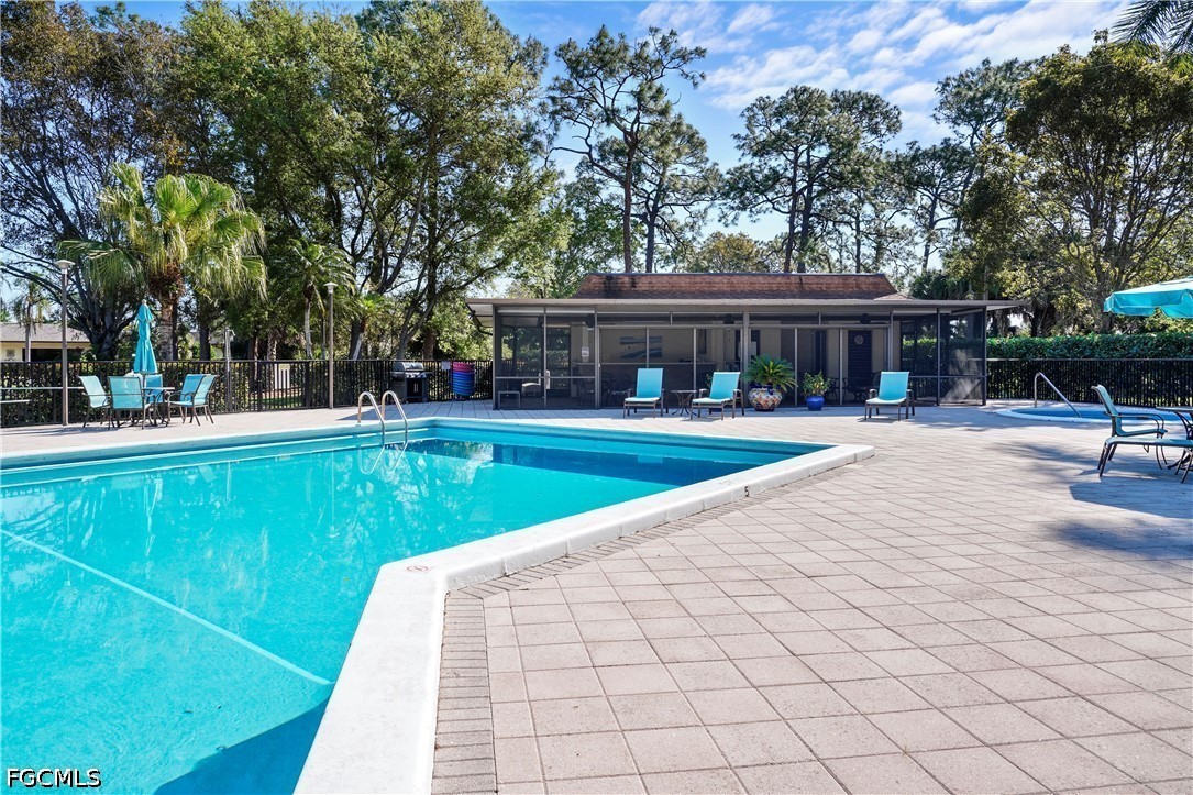 413 Augusta Boulevard, Unit 105 Naples, FL 34113 - Photo 42 of 45 a view of a swimming pool with a bench and trees around