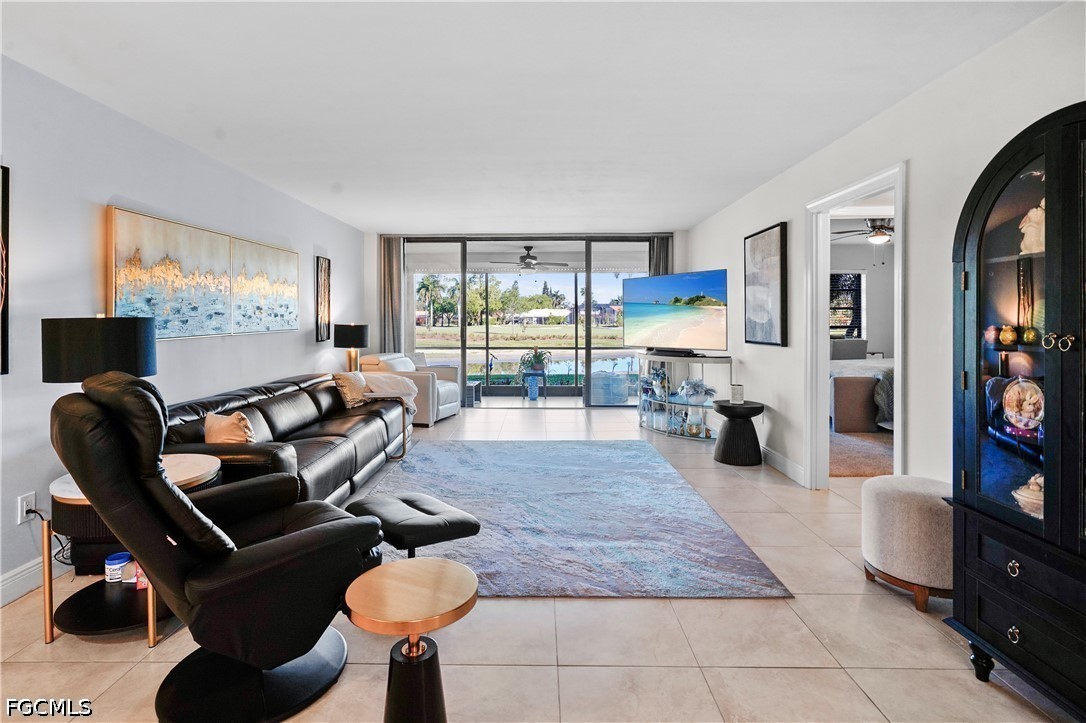 413 Augusta Boulevard, Unit 105 Naples, FL 34113 - Photo 10 of 45 a living room with furniture a flat screen tv and floor to ceiling window