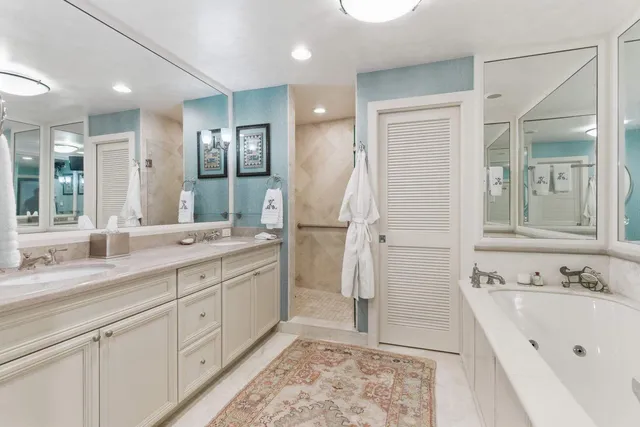 a spacious bathroom with a double vanity sink mirror and bathtub