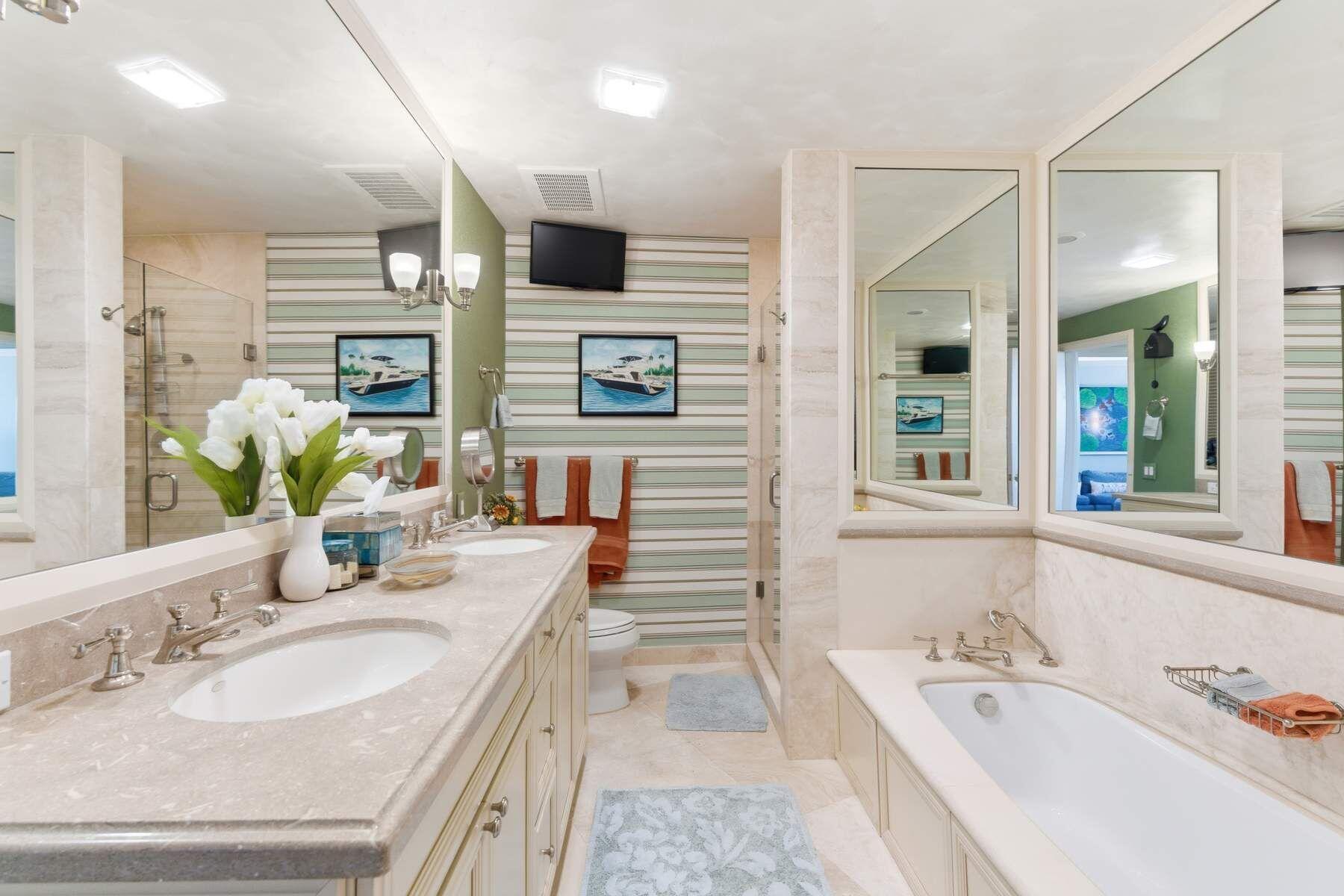 100 Royal Palm Way, Unit F4 Palm Beach, FL 33480 - Photo 22 of 28 a bathroom with a granite countertop sink mirror and bathtub