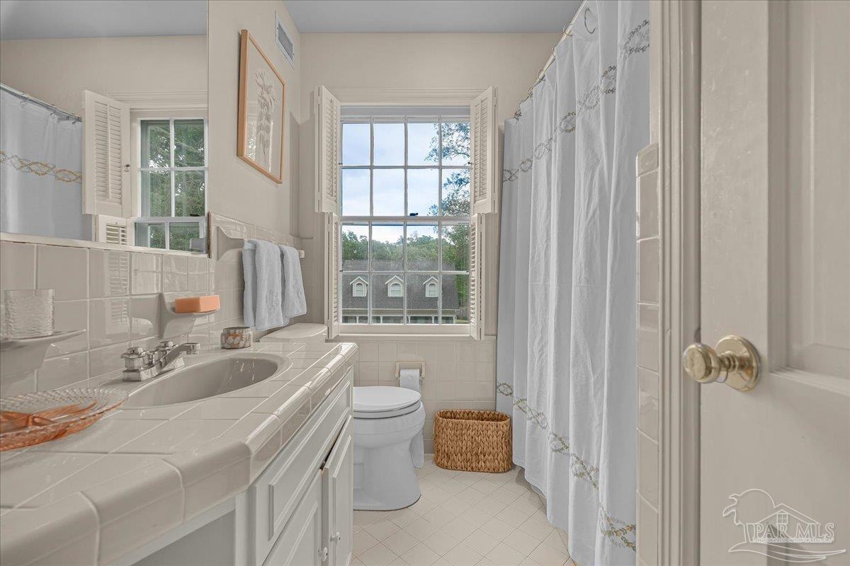 3361 Palermo Road Pensacola, FL 32503 - Photo 47 of 50 a bathroom with a sink toilet a mirror and next to a window