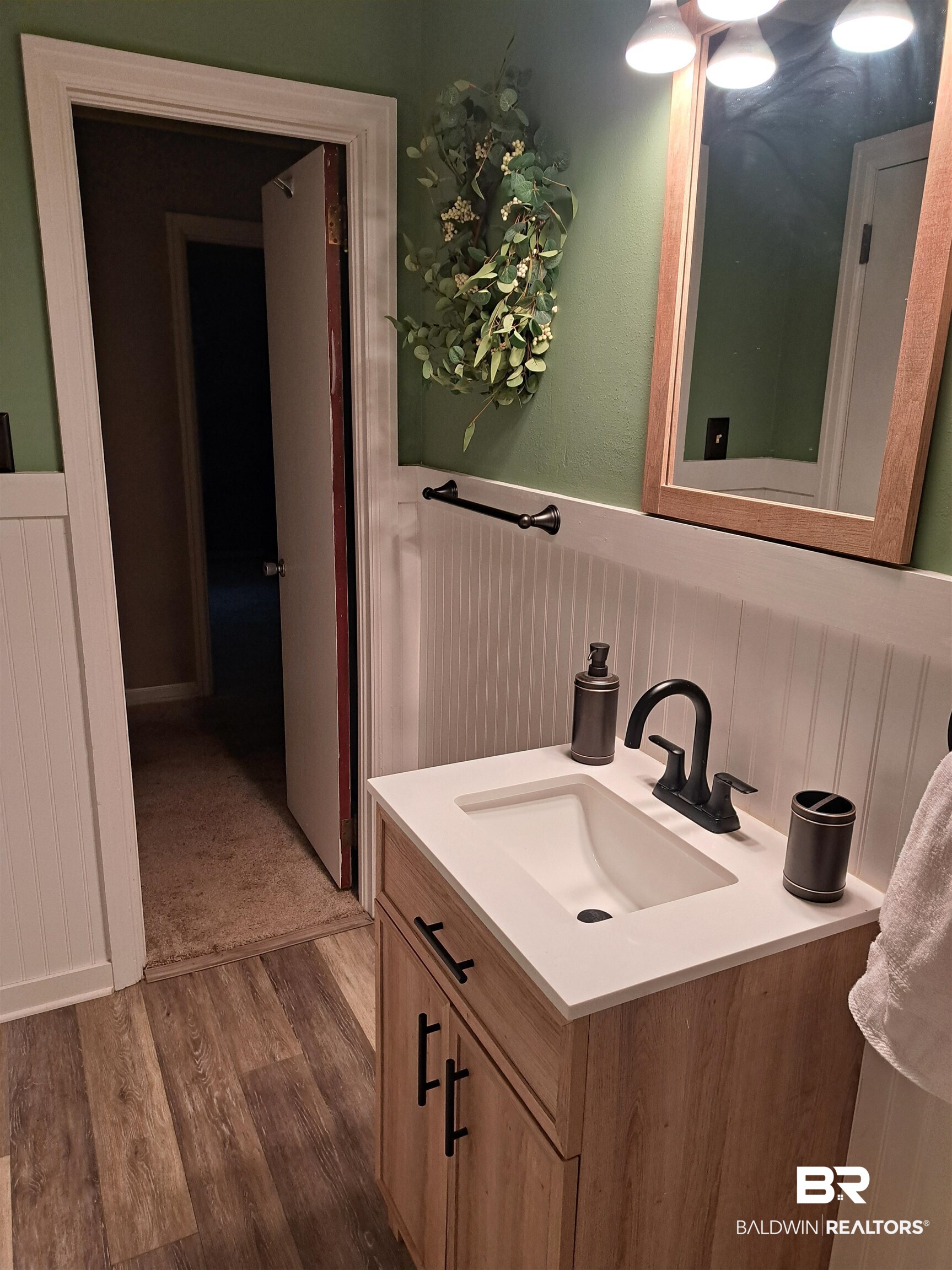 249 Newton Parkway Evergreen, AL 36401 - Photo 11 of 28 Bathroom with vanity, wainscoting, and dark wood-style floors
