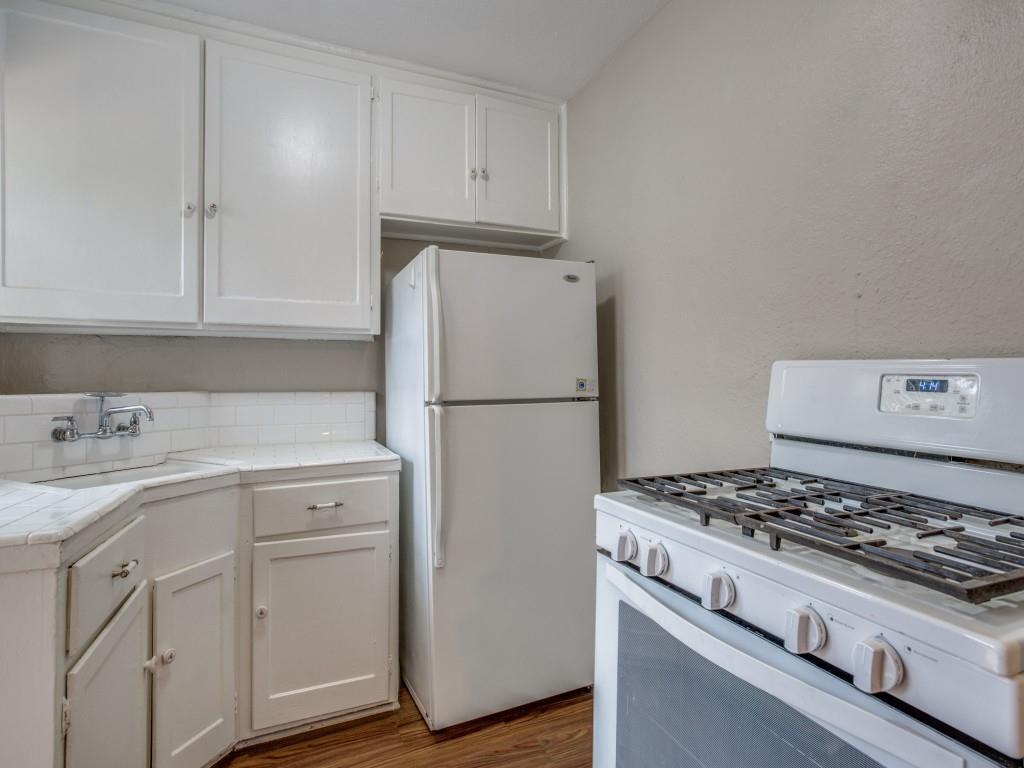 902 Denton Street Denton, TX 76201 - Photo 5 of 11 Functional kitchen with white cabinets and a clean, simple layout.