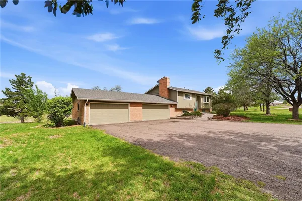 a front view of a house with a yard and trees