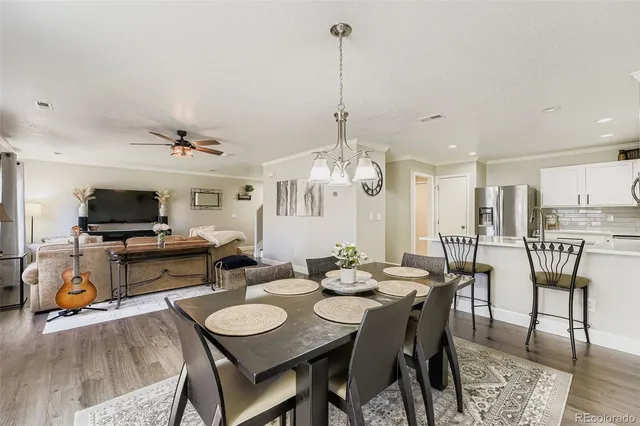 a view of a dining room with furniture a chandelier and wooden floor