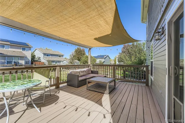 a balcony with wooden floor table and chairs