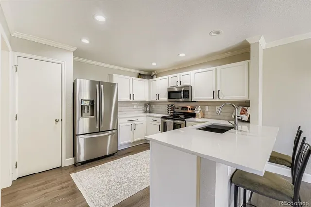 a kitchen with a refrigerator a stove microwave and sink
