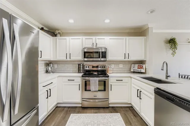 a kitchen with white cabinets and stainless steel appliances