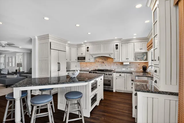 a kitchen with granite countertop a sink stove and cabinets