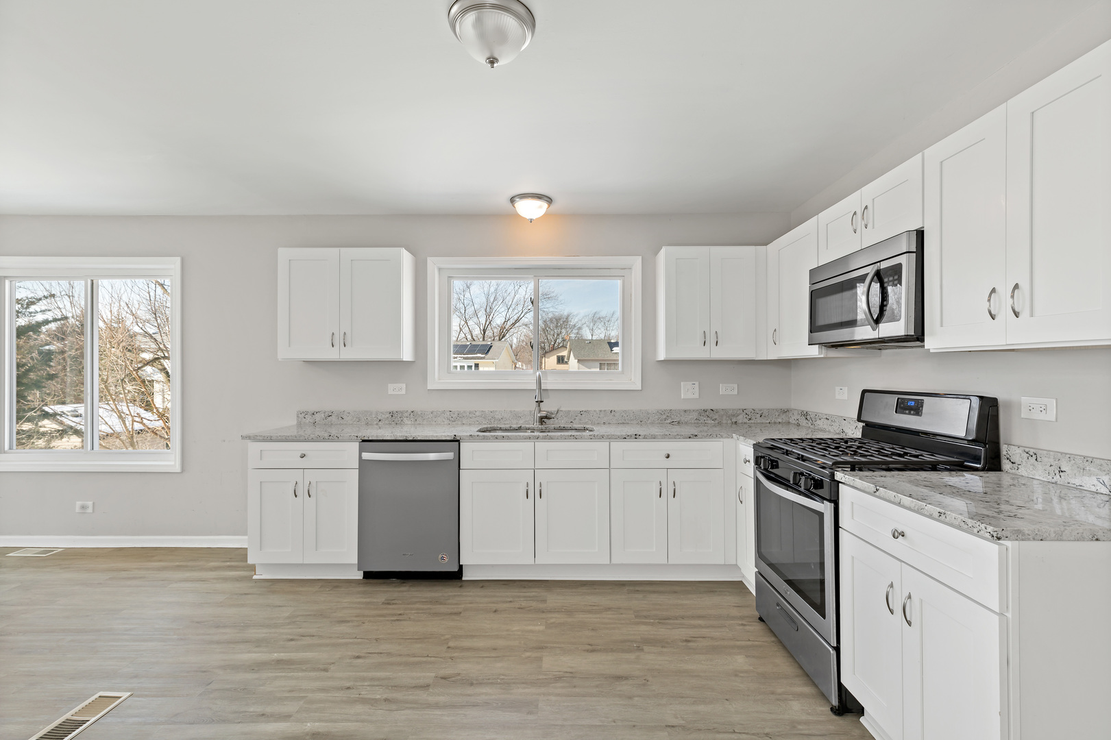 58 Cloverleaf Road Matteson, IL 60443 - Photo 7 of 19 a kitchen with granite countertop white cabinets a sink a window and stainless steel appliances