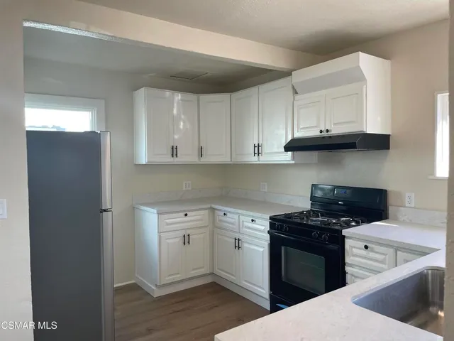 a kitchen with stainless steel appliances granite countertop a stove a sink and a microwave