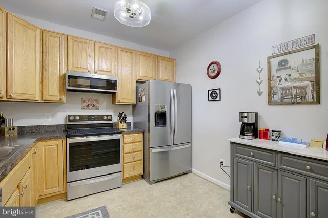 a kitchen with stainless steel appliances a stove a microwave and a refrigerator