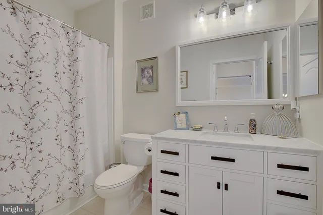 a bathroom with a granite countertop toilet sink and mirror