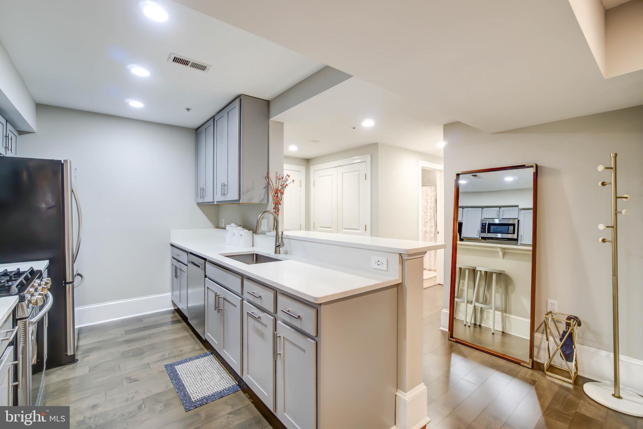 1324 Euclid Street Northwest, Unit 3 Washington, DC 20009 - Photo 6 of 23 a kitchen with kitchen island a counter top space a sink a refrigerator and a view of living room