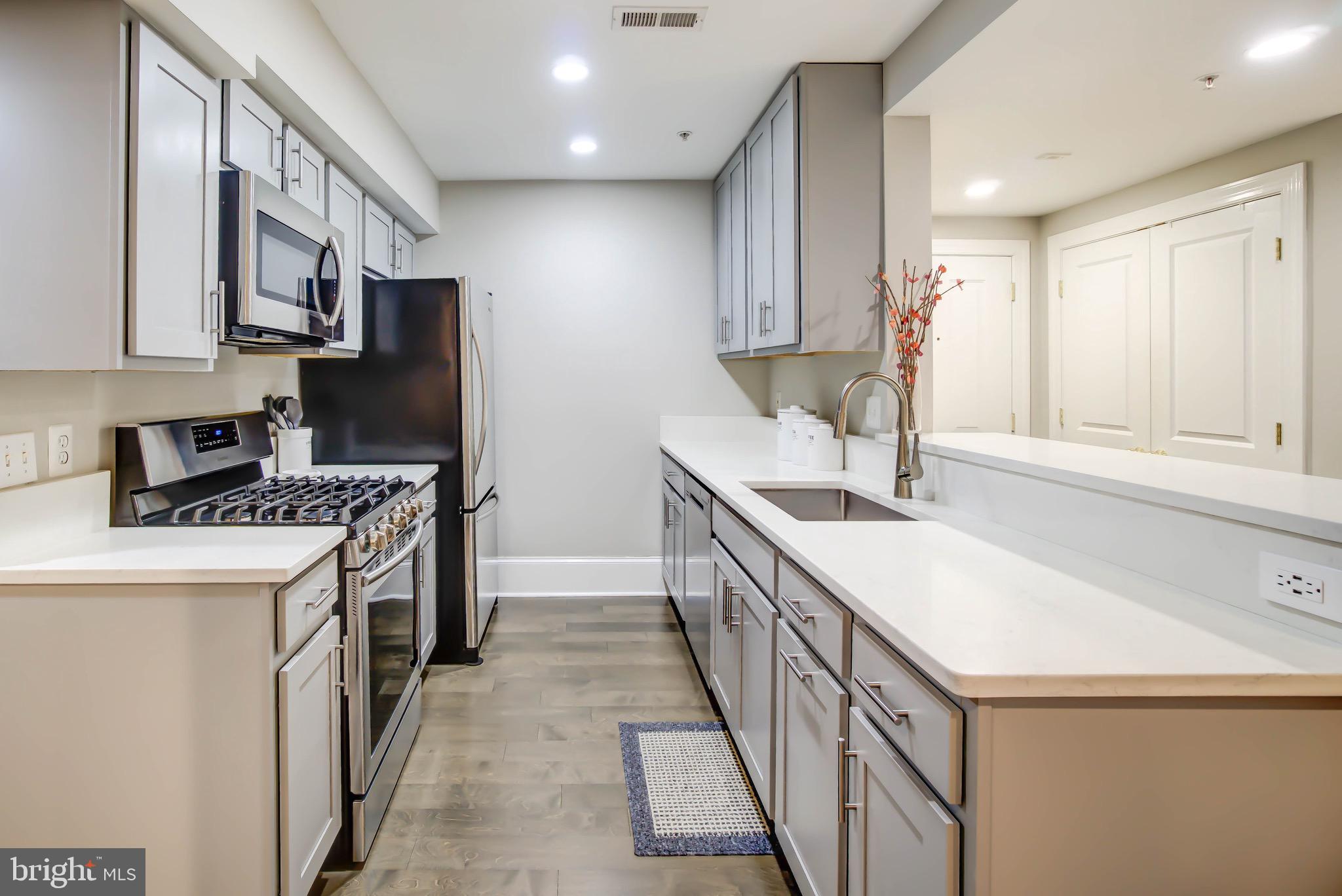 1324 Euclid Street Northwest, Unit 3 Washington, DC 20009 - Photo 7 of 23 a kitchen with stainless steel appliances granite countertop a sink stove and refrigerator