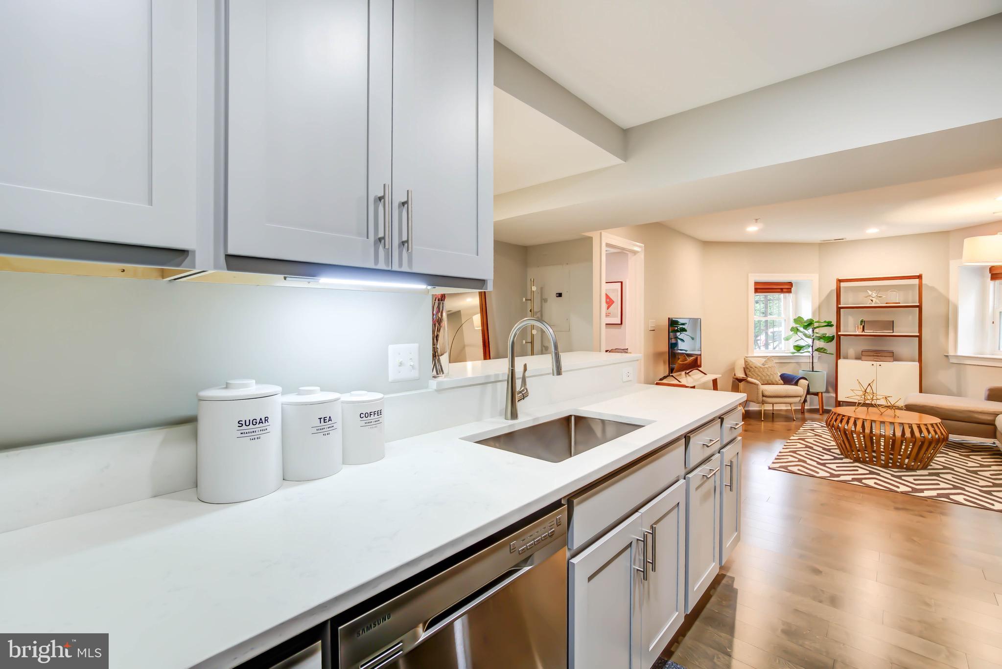 1324 Euclid Street Northwest, Unit 3 Washington, DC 20009 - Photo 9 of 23 a kitchen that has a lot of cabinets a sink and wooden floor