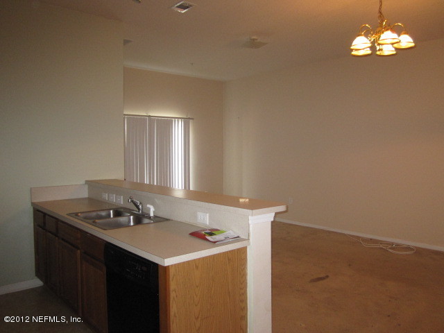 7920 Merrill Road, Unit 1003 Jacksonville, FL 32277 - Photo 4 of 9 a kitchen that has a sink cabinets and wooden floor