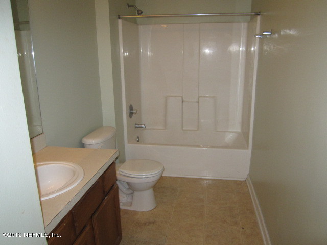 7920 Merrill Road, Unit 1003 Jacksonville, FL 32277 - Photo 7 of 9 a bathroom with a granite countertop sink toilet and shower