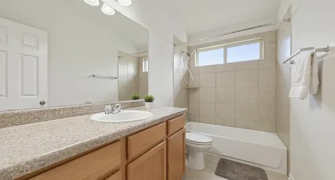 a bathroom with a granite countertop sink mirror toilet and bathtub