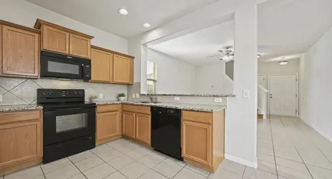 a kitchen with stainless steel appliances granite countertop a stove top oven a sink dishwasher and a microwave oven on the blue kitchen countertops