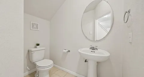 a bathroom with a sink toilet and a mirror