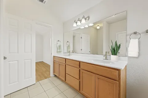 a spacious bathroom with a granite countertop double vanity sink mirror and