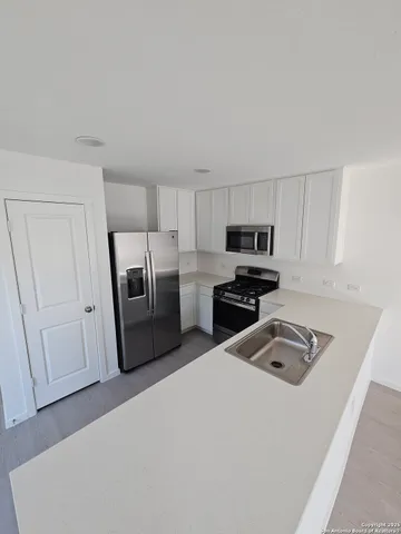 a kitchen with granite countertop a refrigerator sink and stove